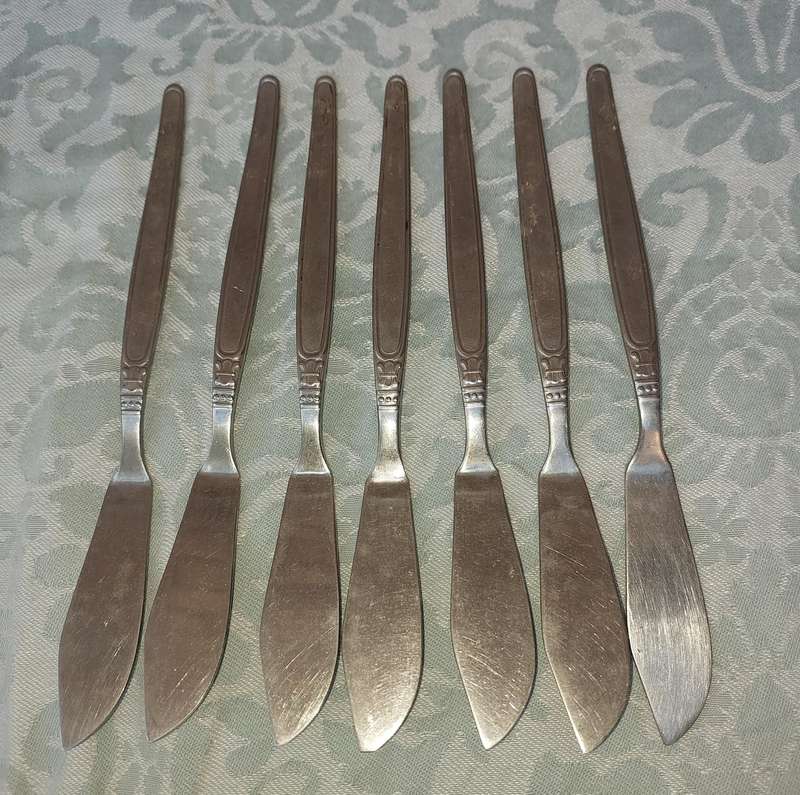 A VINTAGE SET OF 7 UNITY 18/ 8 STAINLESS STEEL FISH KNIVES SOLD AS IS