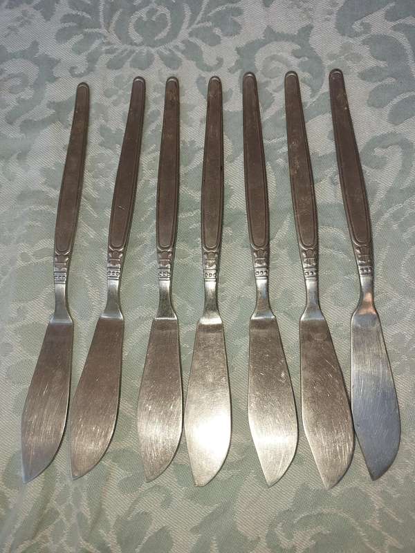 A VINTAGE SET OF 7 UNITY 18/ 8 STAINLESS STEEL FISH KNIVES SOLD AS IS