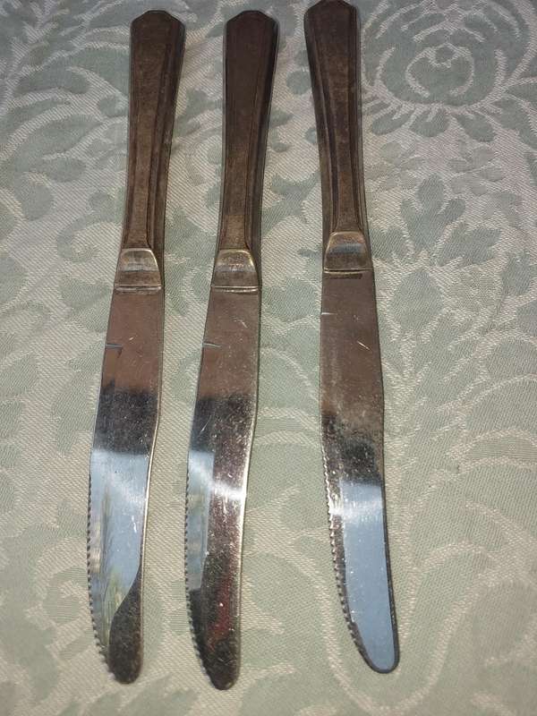 A VINTAGE COLLECTION OF 3 INSINIA PLATE STEAK KNIVES SOLD AS IS