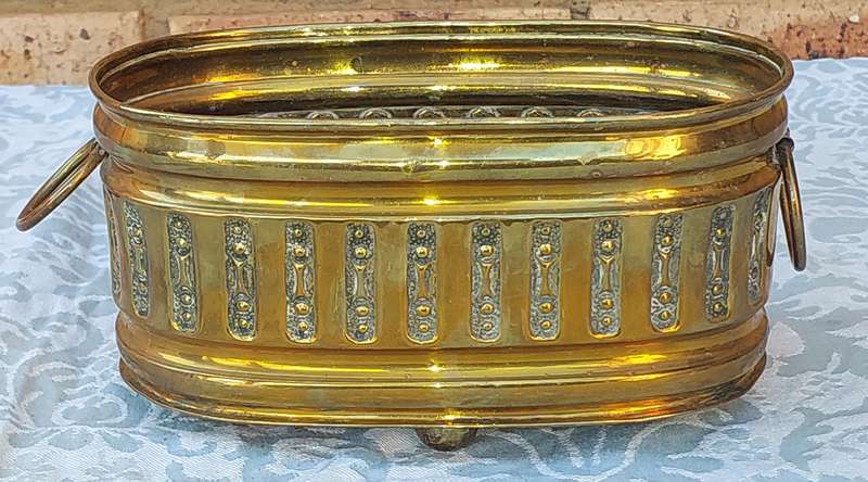 A VINTAGE DOUBLE HANDLED BRASS OVAL PLANTER SOLD AS IS