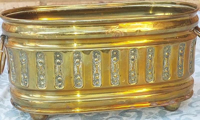 A VINTAGE DOUBLE HANDLED BRASS OVAL PLANTER SOLD AS IS