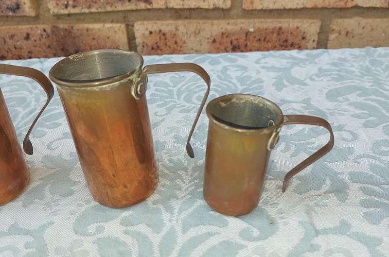 A COLLECTION OF ART DECOR BRASS AND COPPER UTENSILS SOLD AS IS