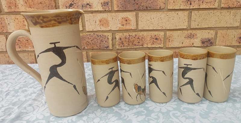 A VINTAGE SET WATER JUG AND FIVE TUMBLERS CERAMICA BY TI POTTERIES WITH AFRICAN DRAWINGS SOLD AS IS