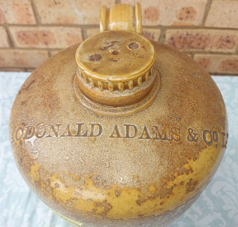 AN ANTIQUE MACDONALD ADAMS & CO LTD GIN CERAMIC JAR WITH A SCREW ON LID NO11  SOLD AS IS