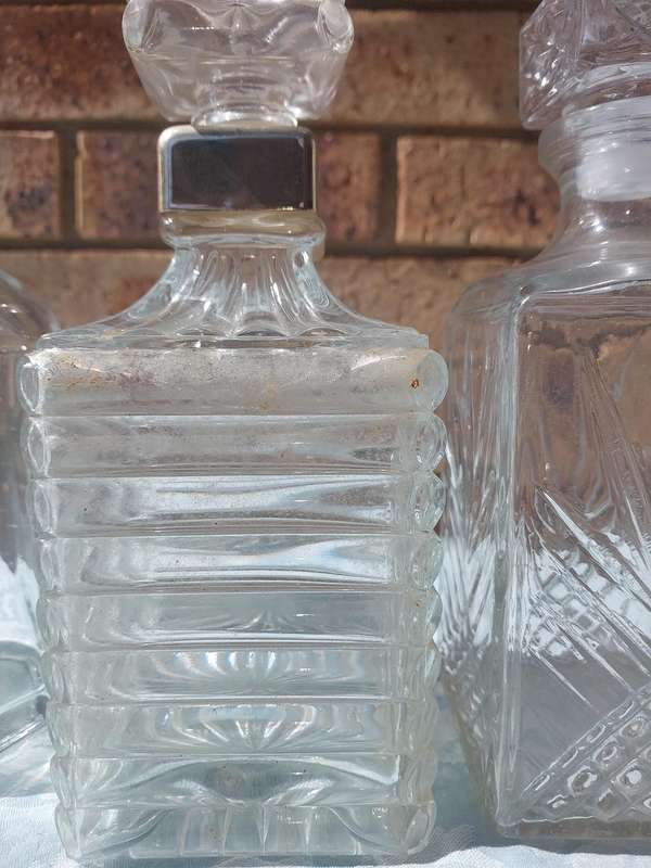 A VINTAGE COLLECTION GLASS DECANTERS FOR THE GENTLEMENS BAR SOLD AS IS