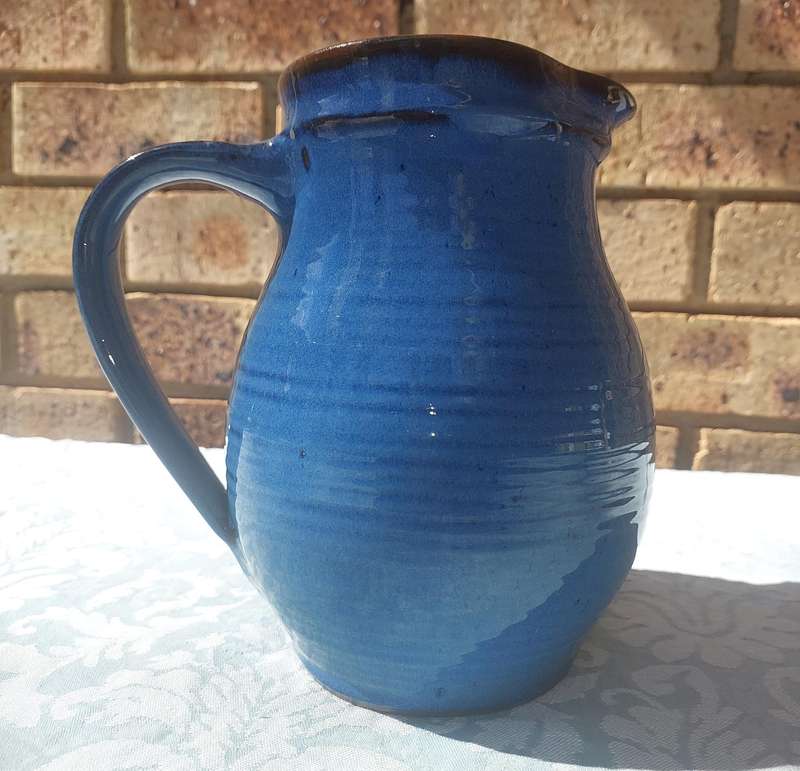 A VINTAGE CERAMIC BLUE GLAZED WATER JUG SOLD AS IS