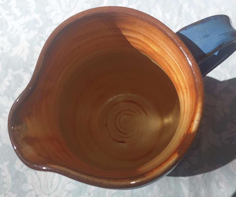 A VINTAGE CERAMIC BLUE GLAZED WATER JUG SOLD AS IS