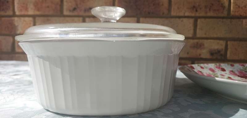 A CORNING WARE CASSEROLE AND A PORCELAIN FLORAL PLATTER SOLD AS IS