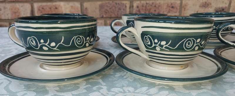 AN OFF WHITE WITH GREEN TRIM STONE WARE COFFEE CUP AND SUGAR BOWL SET SOLD AS IS
