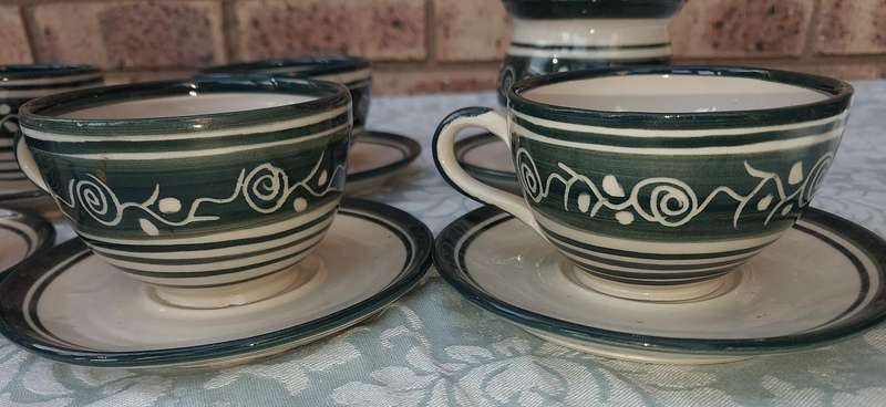 AN OFF WHITE WITH GREEN TRIM STONE WARE COFFEE CUP AND SUGAR BOWL SET SOLD AS IS