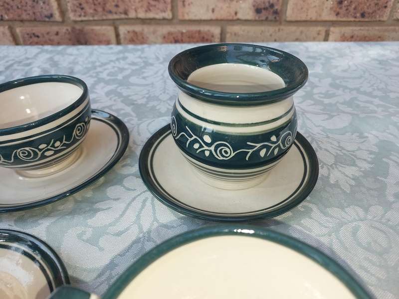 AN OFF WHITE WITH GREEN TRIM STONE WARE COFFEE CUP AND SUGAR BOWL SET SOLD AS IS