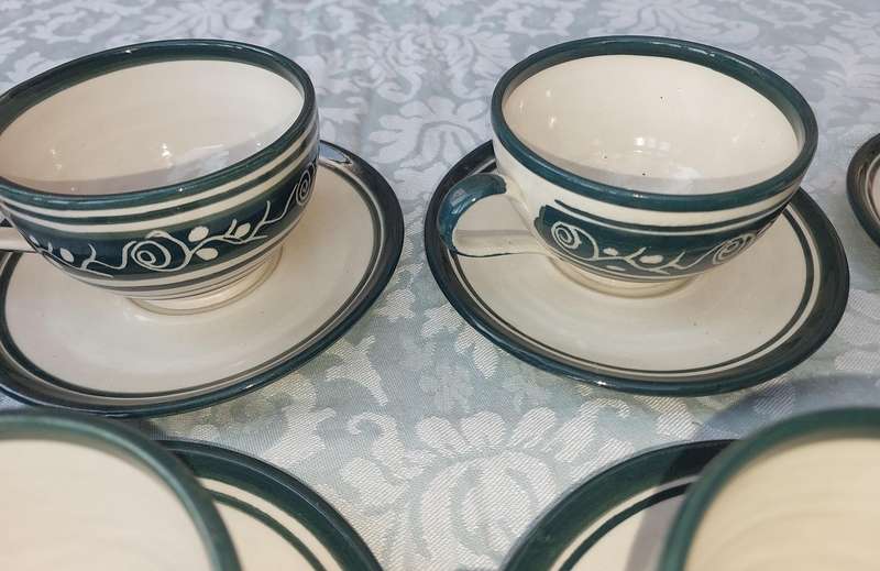 AN OFF WHITE WITH GREEN TRIM STONE WARE COFFEE CUP AND SUGAR BOWL SET SOLD AS IS