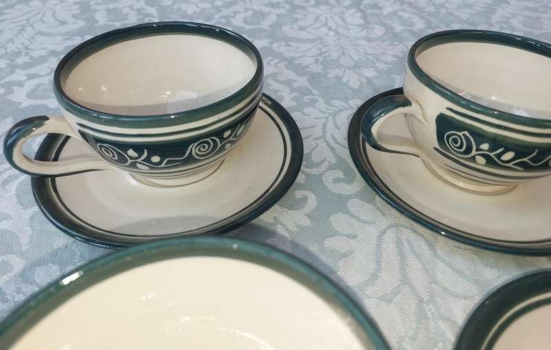 AN OFF WHITE WITH GREEN TRIM STONE WARE COFFEE CUP AND SUGAR BOWL SET SOLD AS IS