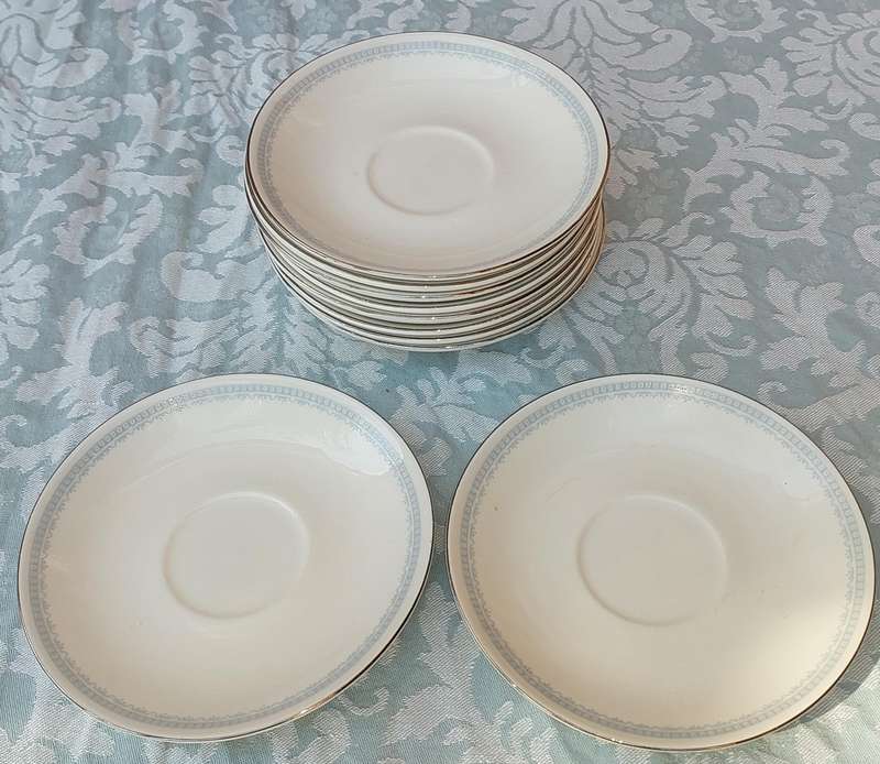 A COLLECTION OF 10 CONTINENTAL SAUCERS WHITE WITH SILVER TRIM AND LIGHT BLUE ART WORK SOLD AS IS
