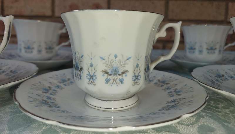 A VINTAGE SET OF 8 TEACUPS AND SAUCERS MADE IN CHINA PORCELAIN WITH FLORAL DESIGN SOLD AS IS