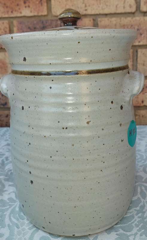 A CERAMIC POTTERY OLIVE JAR WITH A LID SOLD AS IS
