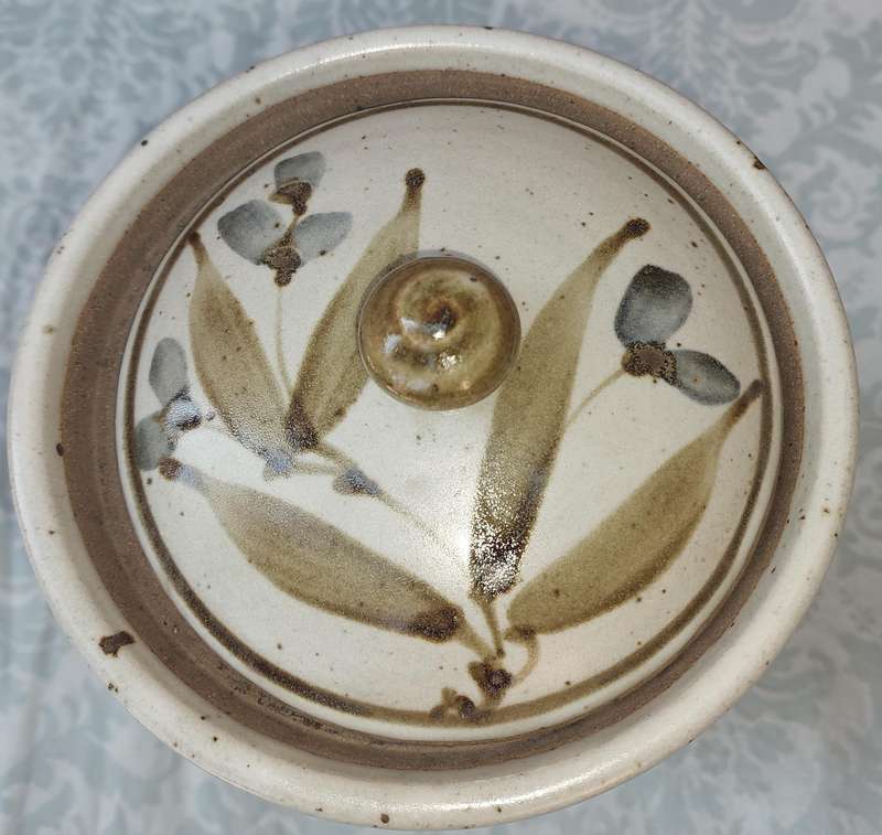 A CERAMIC POTTERY OLIVE JAR WITH A LID SOLD AS IS