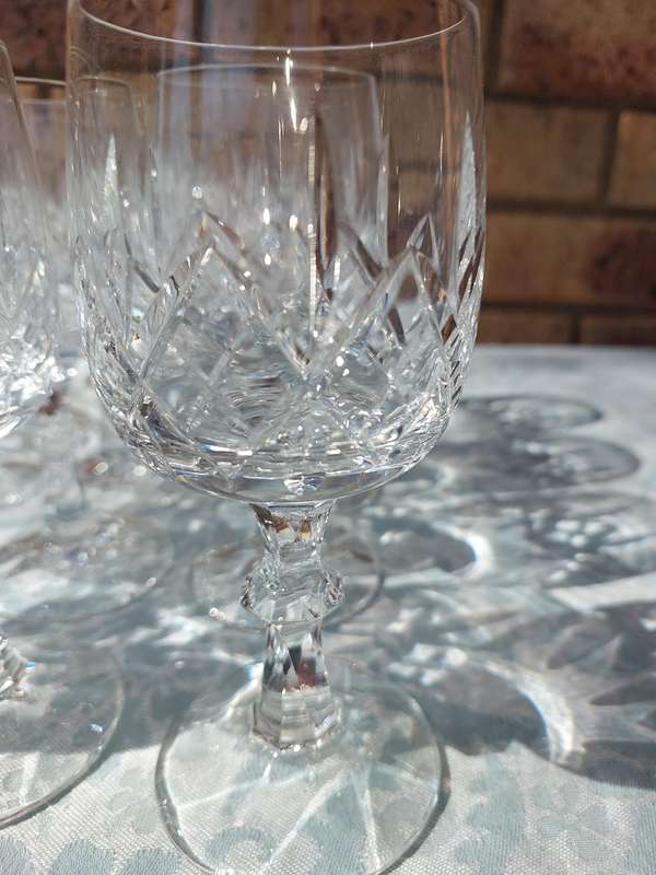 A SET OF 12 CRYSTAL WINE GLASSES WITH STEMS SOLD AS IS