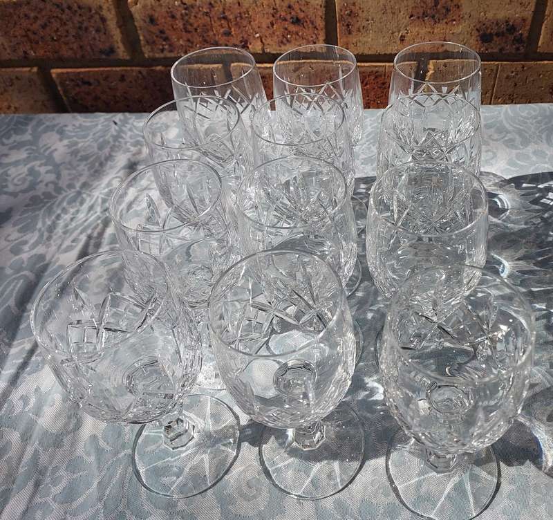 A SET OF 12 CRYSTAL WINE GLASSES WITH STEMS SOLD AS IS