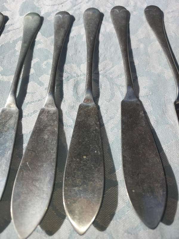 AN ANTIQUE SET OF ATLAS NICKLE SILVER FISH KNIVES SOLD AS IS