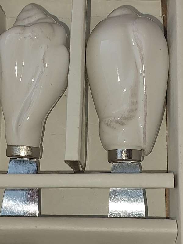A SET OF SEASIDE WITH PORCELAIN HANDLES PAT'E KNIFES SOLD AS IS