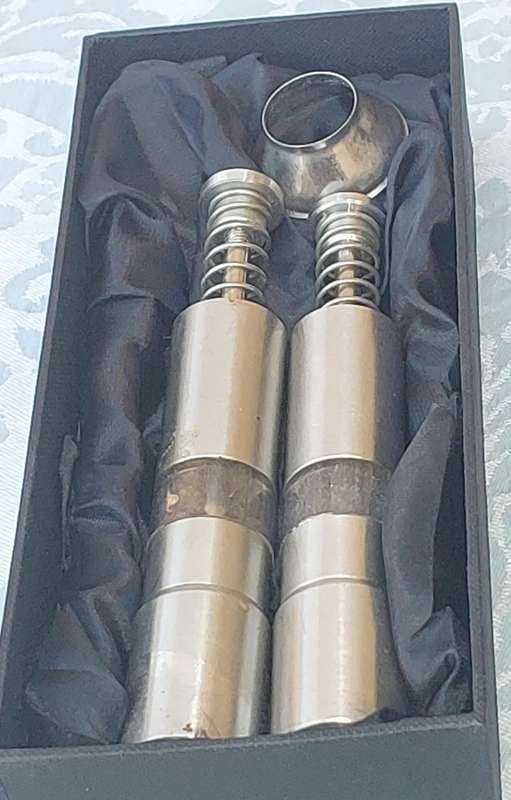 A SET OF STAINLESS STEEL PLUNGER SALT AND PEPPER DISPENSERS