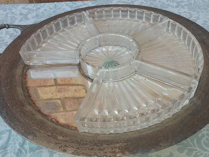 AN ANTIQUE SILVER PLATED WITH HANDLES LAZY SUZAN WITH ONE OF THE GLASS SEGMENT CRACKED SOLD AS IS