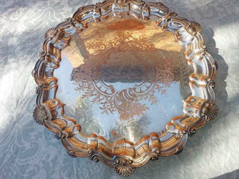 AN ANTIQUE ENGRAVED VICTORIAN FOOTED ROUND SILVER ON COPPER SERVING TRAY SOLD AS IS