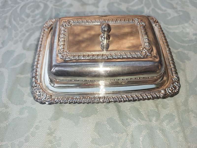 A SILVER PLATED BUTTER DISH WITH A GLASS INSERT SOLD AS IS