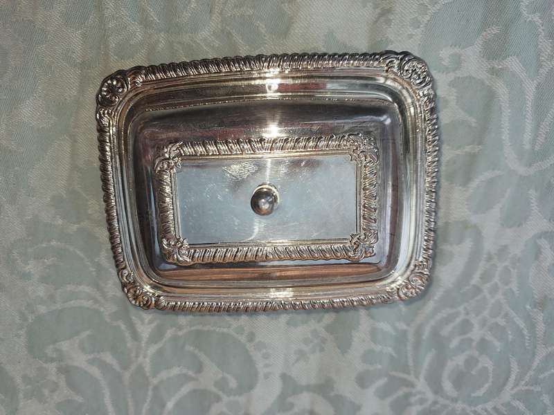 A SILVER PLATED BUTTER DISH WITH A GLASS INSERT SOLD AS IS