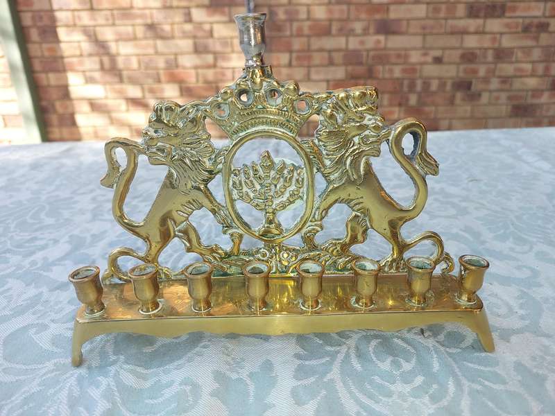 A VINTAGE BRASS CAST HANNUKKA MENORAH WITH LION CRESTS SOLD AS IS