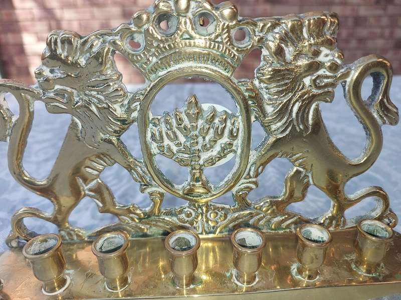 A VINTAGE BRASS CAST HANNUKKA MENORAH WITH LION CRESTS SOLD AS IS