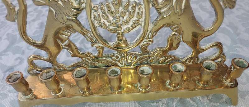 A VINTAGE BRASS CAST HANNUKKA MENORAH WITH LION CRESTS SOLD AS IS
