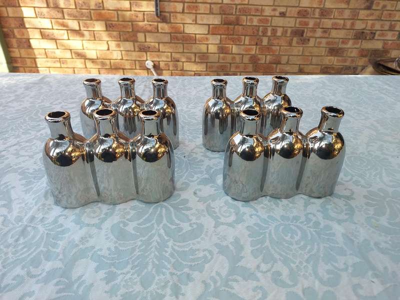 A COLLECTION OF SILVER PLATED CAST BOTTLE VASES SOLD AS IS