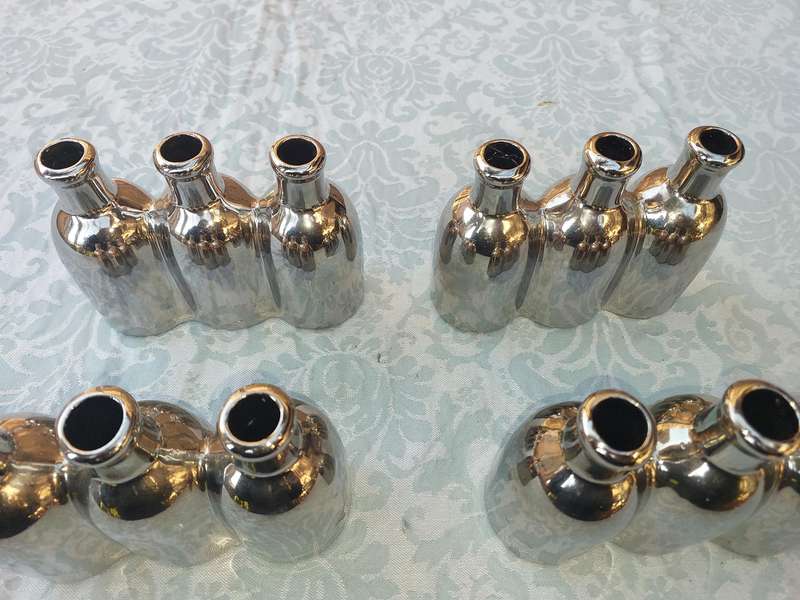 A COLLECTION OF SILVER PLATED CAST BOTTLE VASES SOLD AS IS