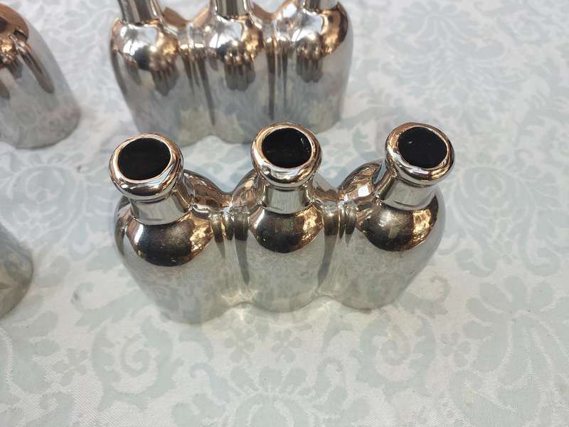 A COLLECTION OF SILVER PLATED CAST BOTTLE VASES SOLD AS IS