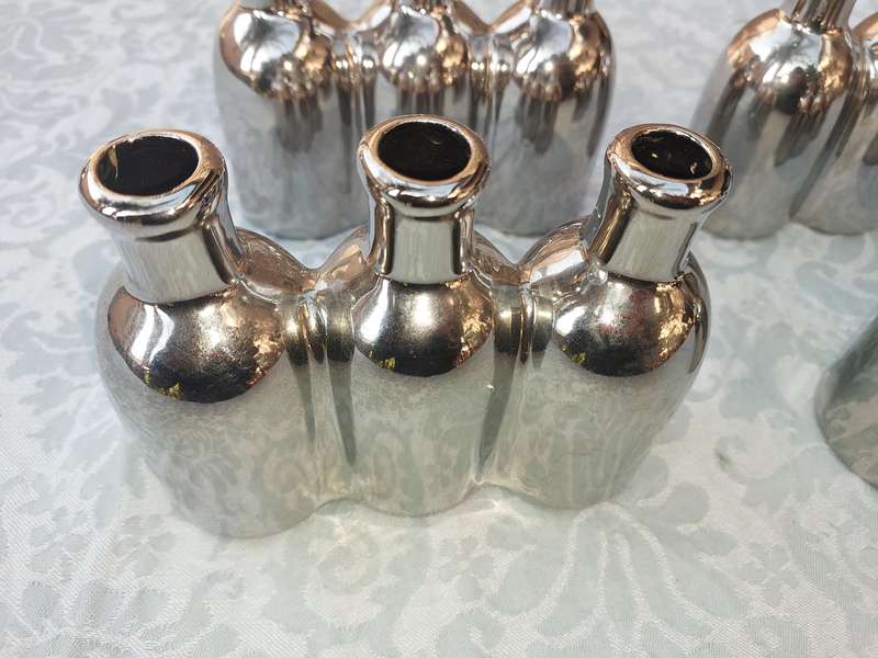 A COLLECTION OF SILVER PLATED CAST BOTTLE VASES SOLD AS IS