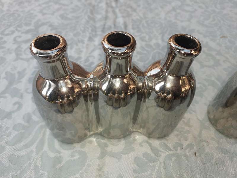 A COLLECTION OF SILVER PLATED CAST BOTTLE VASES SOLD AS IS