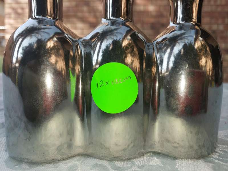 A COLLECTION OF SILVER PLATED CAST BOTTLE VASES SOLD AS IS
