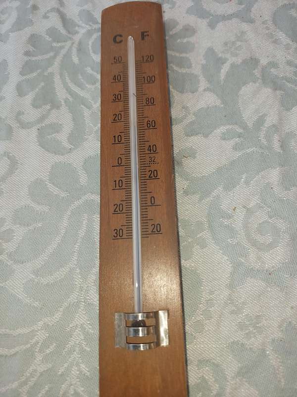 A WOODEN THERMOMETER SOLD AS IS
