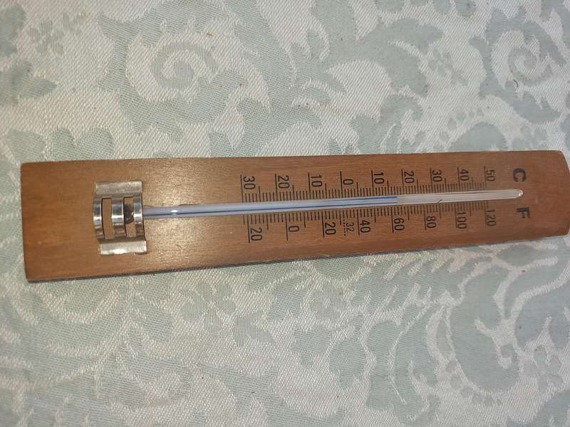 A WOODEN THERMOMETER SOLD AS IS