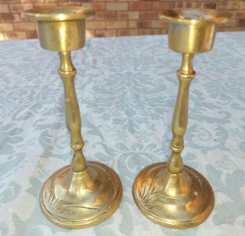A SET OF ORNATE BRASS CANDLE HOLDERS SOLD AS IS