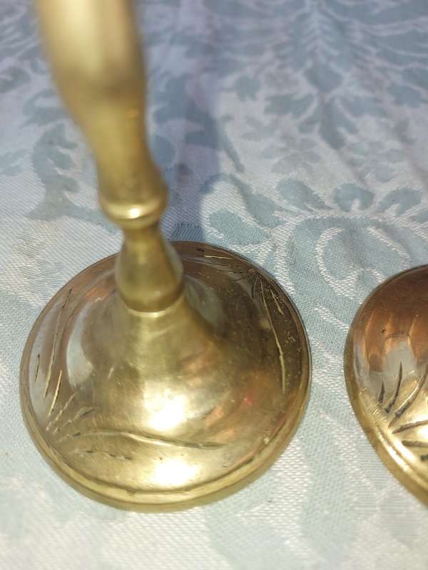 A SET OF ORNATE BRASS CANDLE HOLDERS SOLD AS IS