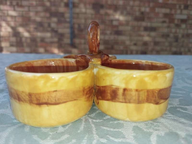 A HANDMADE CERAMIC THREE-COMPARTMENTED CONDIMENT CADDY SOLD AS IS