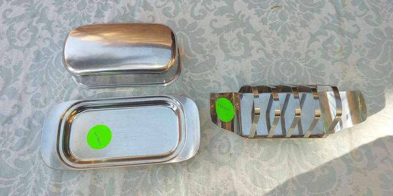 TWO STAINLESS STEEL UTENSILS A BUTTER DISH AND A TOAST STAND SOLD AS IS