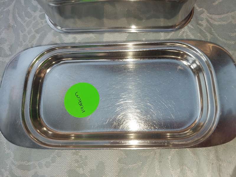TWO STAINLESS STEEL UTENSILS A BUTTER DISH AND A TOAST STAND SOLD AS IS