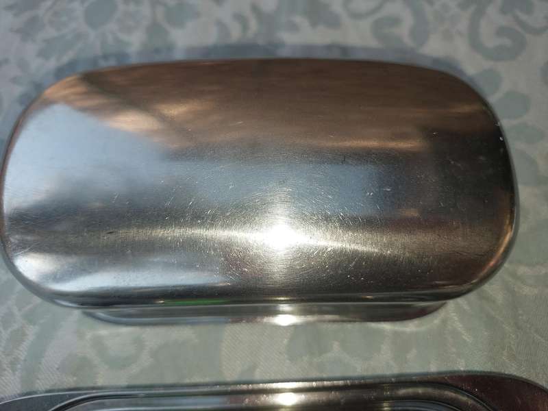 TWO STAINLESS STEEL UTENSILS A BUTTER DISH AND A TOAST STAND SOLD AS IS