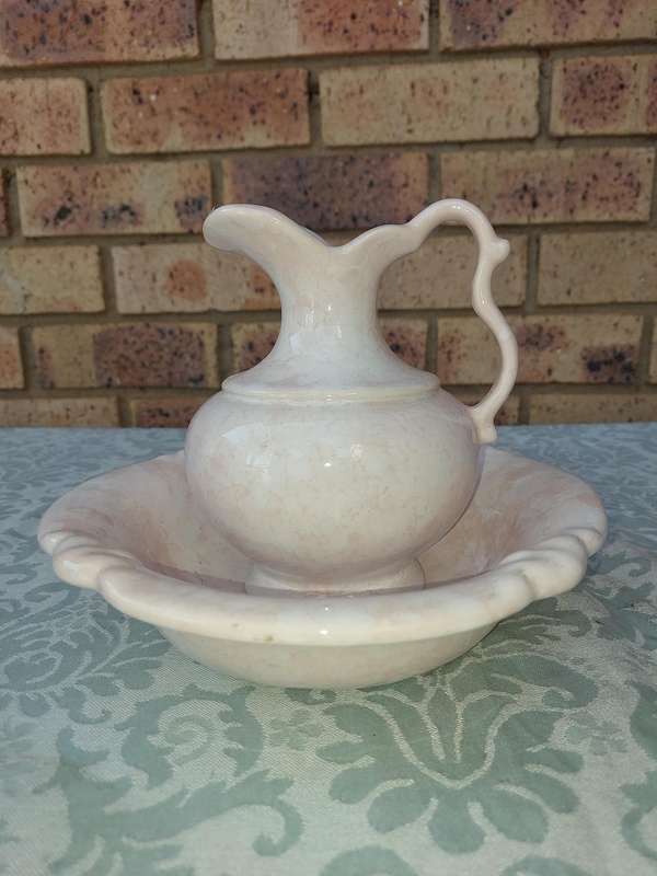 A PINK WATER PITCHER AND A BOWL PINK CERAMIC SOLD AS IS