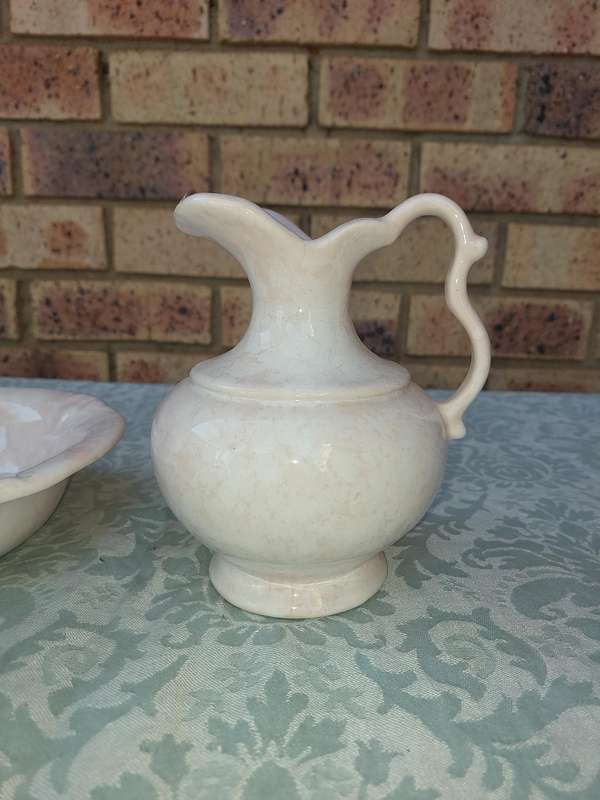 A PINK WATER PITCHER AND A BOWL PINK CERAMIC SOLD AS IS