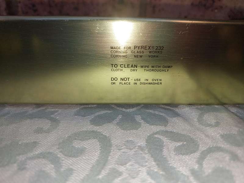 A VIBTAGE B PYREX CORNING CASSEROLE AND A STAND SOLD AS IS